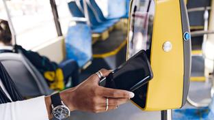 Eine Person hält das Smartphone an das Lesegerät im Bus. (Foto: picture alliance / Westend61 | Katharina und Ekaterina)