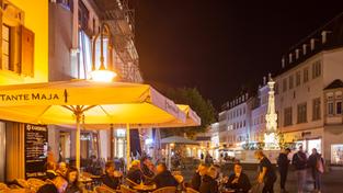 Gäste genießen den Abend in einem der Cafès am St. Johanner Markt. (Foto: IMAGO / Volker Preußer)