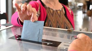 Eine Frau steckt den Wahlumschlag zur Parlamentswahl in die Wahlurne. (Foto: IMAGO / MAXPPP / Stéphanie Para)