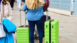 Reisende stehen wartend bei ihren Koffern (Foto: IMAGO / Bihlmayerfotografie)