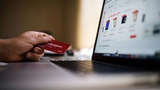 Illustration Onlineshopping: jemand hält eine Kreditkarte in der Hand vor einem Computer (Foto: pexels/Negative Space)