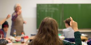 Eine Schülerin meldet sich im Unterricht (Foto: picture alliance / dpa | Julian Stratenschulte)