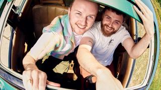 Zwei Männer schauen aus einem Dachfenster eines Autos. Beide lachen in die Kamera. (Foto: Pressefoto/Disclosure)