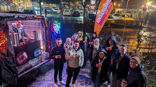 Das Team vom Architektenbüro in Eppelborn steht gemeinsam mit dem UNSERDING Team vor'm Weihnachtsmobil mit Glühwein. (Foto: UNSERDING)